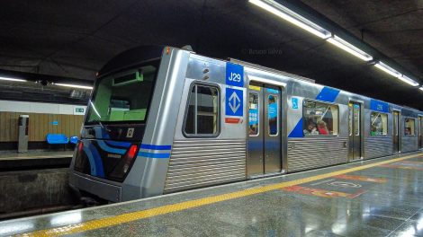 Metrô da linha 1 azul de São Paulo na plataforma de embarque, visto lateralmente.