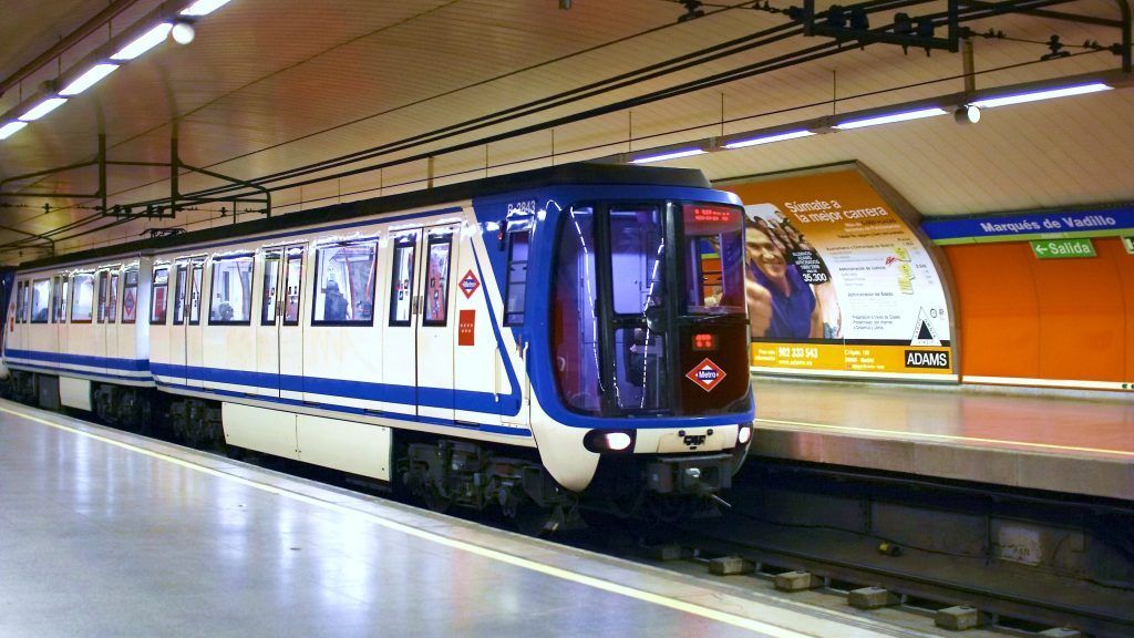 Metro de Madrid. Estação Marqués de Vadillo. Trem azul e branco visto na plataforma de embarque da estação visto lateralmente.
