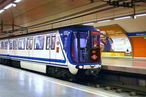 Metro de Madrid. Estação Marqués de Vadillo. Trem azul e branco visto na plataforma de embarque da estação visto lateralmente.