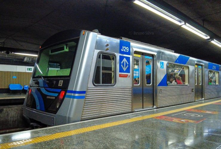 Metrô da linha 1 azul de São Paulo na plataforma de embarque, visto lateralmente.